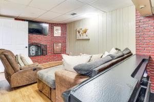 a living room with a couch and a brick wall at 3 Mi to South Park Quiet Pittsburgh Area Getaway in Option