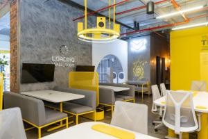 un comedor con mesas y sillas amarillas y blancas en Indie Universe Creative Hotel, en Medellín