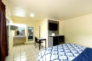 Un dormitorio con una cama y un escritorio y una cocina. en Americas Best Value Inn San Antonio Airport South, en San Antonio