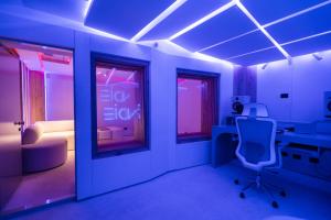 a blue room with a chair and a desk and window at Indie Universe Creative Hotel in Medellín