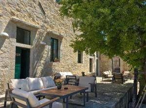 a patio with a table and chairs next to a building at Historic Han Hideaway in Vrana