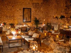 a room with tables and chairs and a stone wall at Historic Han Hideaway in Vrana