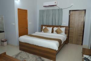 a bedroom with a bed with white sheets and pillows at Hotel Grand Arena in Retang