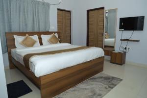 a bedroom with a large bed and a television at Hotel Grand Arena in Retang