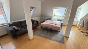 a living room with a bed and a couch at Hotel Der Tannenbaum in Munich