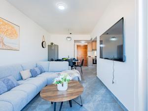 a living room with a blue couch and a table at TelMar Sky View in Larnaca