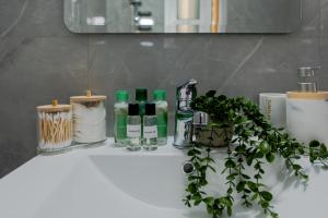 a bathroom sink with green bottles and a plant on it at TelMar Sky View in Larnaca +45 photos