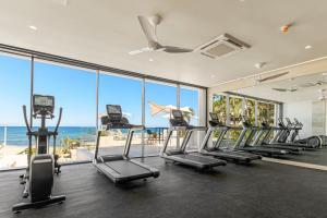 a gym with rows of exercise bikes and the ocean at Oceanfront Infinity Pool Vera Neo Beach Club Gym in San José del Cabo