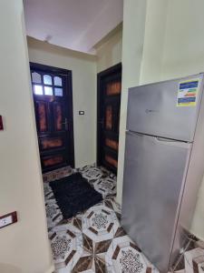 een keuken met een koelkast en een tegelvloer bij Palm Apartments Siwa in Siwa +8 foto's