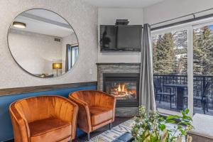 a living room with two chairs and a fireplace at Amazing Views 1BR Condo with Hot Tub and Pool in Canmore