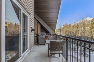 a balcony of a house with a grill on it at Amazing Views 1BR Condo with Hot Tub and Pool in Canmore