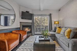 a living room with a couch and a fireplace at Amazing Views 1BR Condo with Hot Tub and Pool in Canmore +21 photos