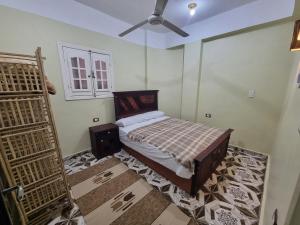 een slaapkamer met een bed en een plafondventilator bij Palm Apartments Siwa in Siwa