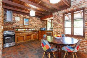 eine Küche mit einem Holztisch und einer Ziegelwand in der Unterkunft Burn Street Loft - North Fremantle in North Fremantle