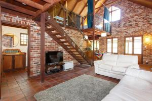 ein Wohnzimmer mit einem weißen Sofa und einer Ziegelwand in der Unterkunft Burn Street Loft - North Fremantle in North Fremantle