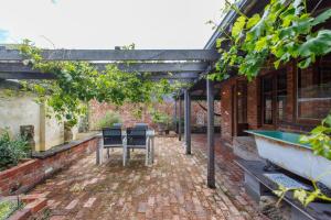 eine Außenterrasse mit einem Tisch und einer Badewanne in der Unterkunft Burn Street Loft - North Fremantle in North Fremantle