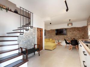 a living room with stairs and a stone wall at Ana Stone House Jurcic Kalic in Vranjak