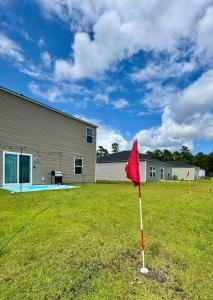 a red flag in the grass in front of a building at Golf and Beach Getaway in Sunset Beach