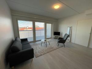 a living room with a couch and a table and chairs at Central Apartment for 4 with Sauna in Seinäjoki