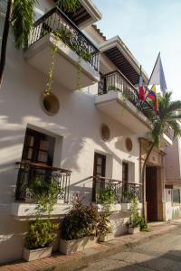 um edifício branco com varandas e vasos de plantas em Hotel Boutique Patio Corao em Cartagena de Indias