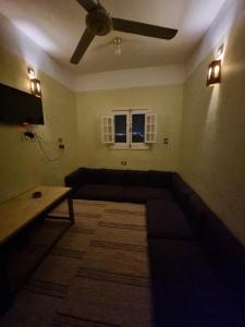 een woonkamer met een bank en een plafondventilator bij Palm Apartments Siwa in Siwa