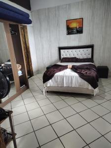 a bedroom with a bed and a tiled floor at Beleza de Angra Apartamento Aconchegante in Angra dos Reis