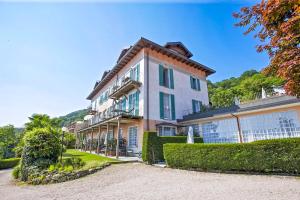 a large white building with bushes in front of it at Villa Anna Isole Borromee in Baveno