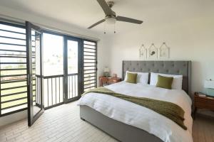 a bedroom with a large bed with a ceiling fan at Selah in Palmas del Mar in Buena Vista