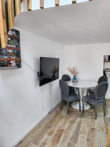 Un comedor con mesa y sillas y un televisor. en Coquet Studio avec Jardin à Ballan-Miré, en Ballan-Miré