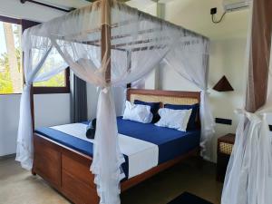 a bedroom with a canopy bed with blue sheets at Amarante Madiha in Matara +54 photos