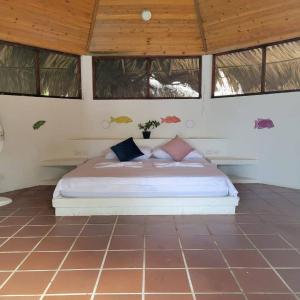 a bedroom with a bed in a room with windows at Ecohotel Nativa Beach in Cartagena de Indias