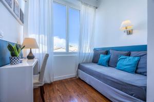 a blue bedroom with a bed and a window at B&B La Halte Montaigne in Bordeaux