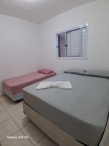 two beds in a room with a window at Casa de férias Pôr do Sol 2 in Presidente Epitácio +20 photos
