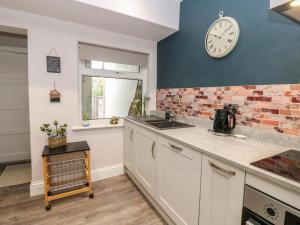 a kitchen with a clock on the wall at 57 Cockpit Hill in Northallerton