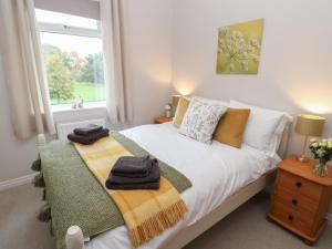 a bedroom with a white bed with a window at 57 Cockpit Hill in Northallerton