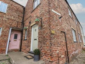 a brick building with a pink door and a pink door at 57 Cockpit Hill in Northallerton