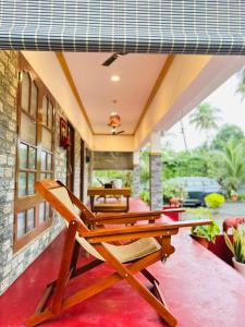 a patio with a table and chairs on a porch at 4elementis beach homestay in Mararikulam