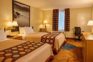 a hotel room with two beds and a desk at MHO Hotel Dover in Dover