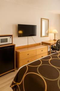 a hotel room with a bed and a flat screen tv at MHO Hotel Dover in Dover