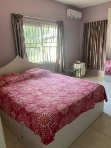 een slaapkamer met een bed met een rood dekbed bij Peperpot City in Meerzorg