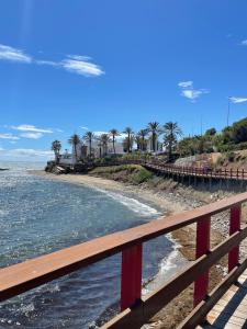 a bridge over a beach with palm trees and the ocean at Costa del Sol with proximity to the sea and golf in Sitio de Calahonda