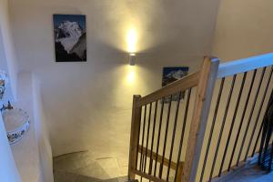 een trap met twee schilderijen aan de muur en een houten leuning bij Village House In The Heart Of Saint Chaffrey in Saint-Chaffrey