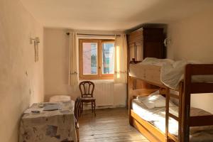 een kamer met 2 stapelbedden, een tafel en een raam bij Village House In The Heart Of Saint Chaffrey in Saint-Chaffrey