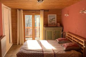 een slaapkamer met een bed voor een raam bij Village House In The Heart Of Saint Chaffrey in Saint-Chaffrey