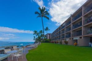 a hotel with a lawn in front of the ocean at Kaleialoha 401 · KA 401 Spacious Studio w Mountain View Pool AC in Kahana