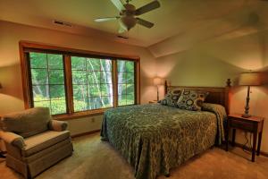 a bedroom with a bed and a chair and a window at Penrith Hideaway at Yonahlossee in Boone +28 photos