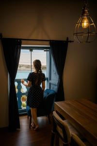 库斯科Apartamento Familiar con balcón y vista a la Ciudad, Centro的坐在窗前椅子上的女人