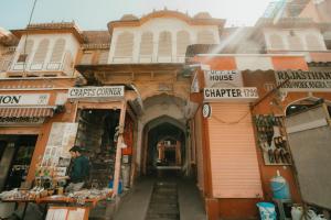 an alley in a city with a man standing in front of buildings at Jai Kutir Homestay - Hawa Mahal View in Jaipur