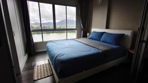 a bed in a room with a large window at D Condo mine Kathu in Kathu +11 photos