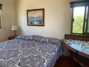ein Schlafzimmer mit einem Bett und einem Bild an der Wand in der Unterkunft Casitas Las Palmas - Brisa Marina in Punta Mita